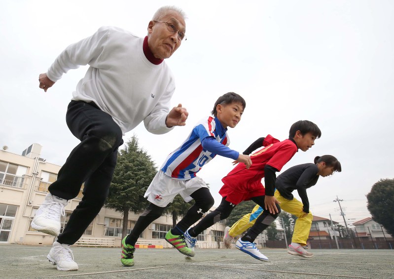 五輪公式ポスターのモデルになった岡本政彰さんが孫たちとスタートダッシュする=千葉県流山市の同市立江戸川台小学校で、宮武祐希撮影