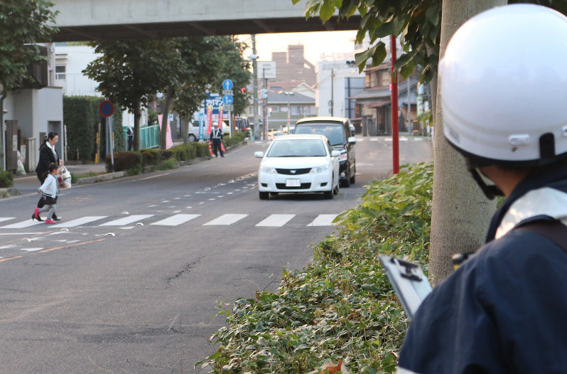 信号機のない横断歩道で取り締まりに当たる警察官(右手前)=愛知県瀬戸市で2016年11月、野村阿悠子撮影