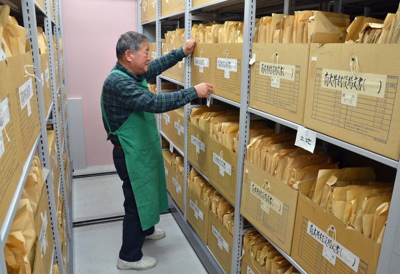 書架に収蔵した古文書入り段ボール箱を整理する職員=小諸市大手の市古文書調査室で