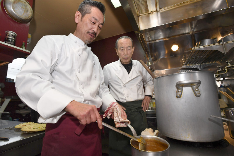 父の保さん(奥)から東京五輪の選手村で提供したカレーのレシピを引き継ぐ横山修
さん。保さんも調理場を手伝う=石川県加賀市で昨年12月、川平愛撮影