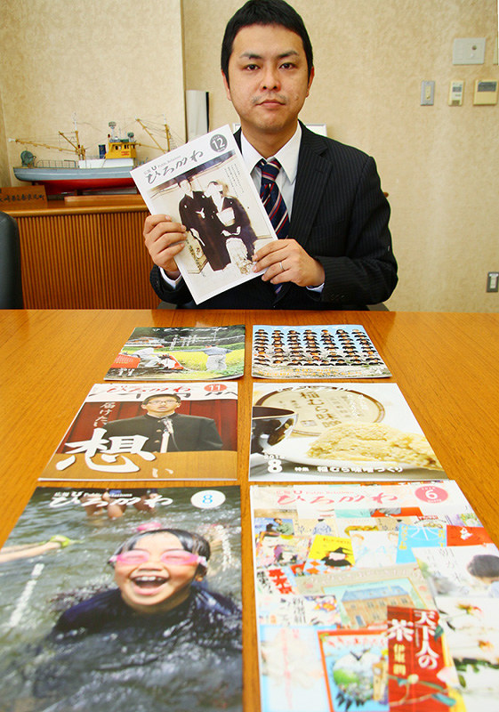 認知症を特集した「広報ひろがわ」を手にする金丸さん。他の号でも雑誌を並べた写真を使うなど工夫をこらしている=和歌山県広川町で、稲生陽撮影