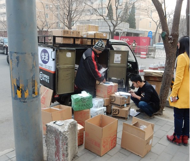 ネット通販の浸透で宅配需要が増す中、道端に荷下ろしされた荷物を、近隣住民が受け取りにくるスタイルも定着している=中国北京市内で1月17日、赤間清広撮影