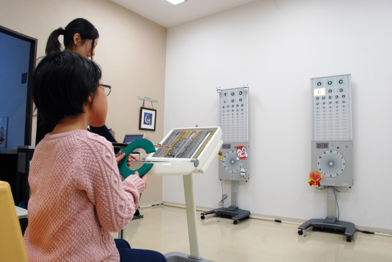 治療用眼鏡で視力を測る子供=東京都中央区の日本橋はま眼科クリニックで