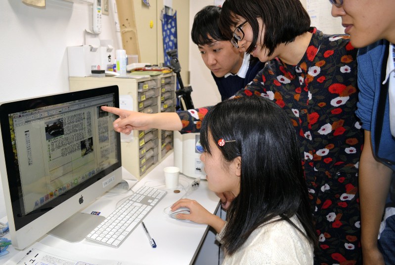 仲間と見出しを相談しながら、筑波大学新聞の次号の紙面をレイアウトする学生=筑波大学で