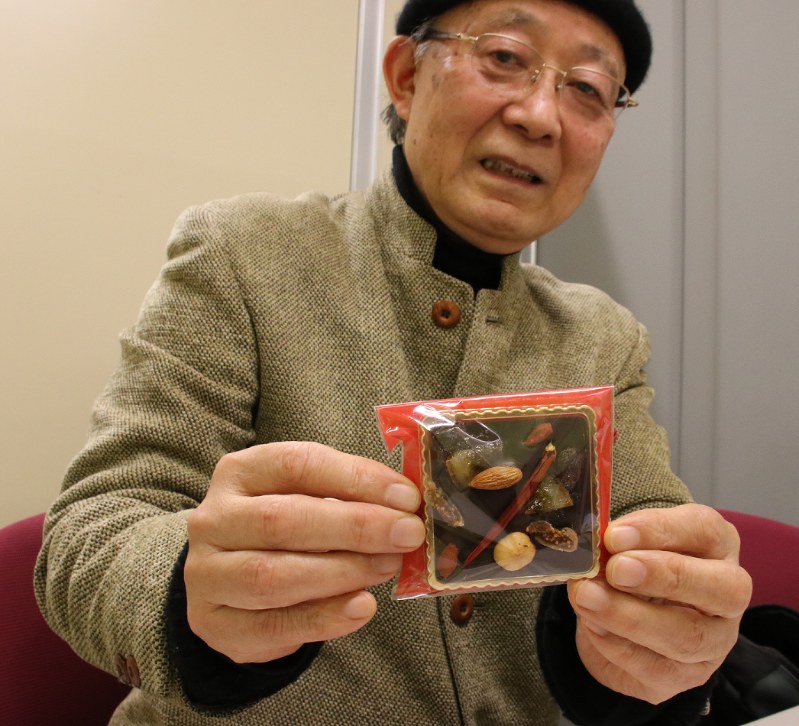 「内藤とうがらしが入ったチョコレート」を手にする成田さん=東京都千代田区で2017年1月26日、篠崎真理子撮影