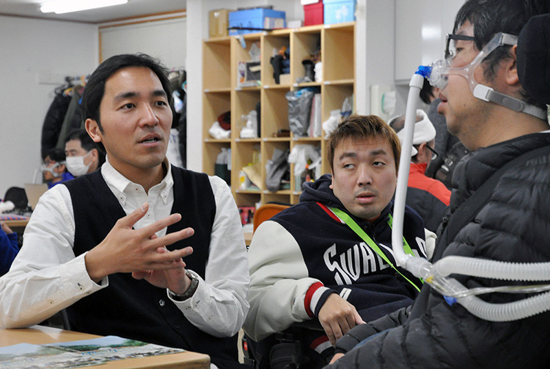 人工呼吸器利用者と話をする宍戸大裕監督(左)=兵庫県西宮市で、田辺佑介撮影