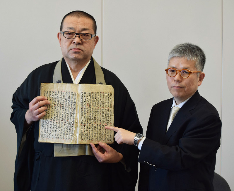 金西寺に伝わる「当寺御開山御真筆」を手にする高崎俊幸住職(左)と調査した島田大助・豊橋創造大教授=愛知県豊橋市役所で、石塚誠撮影