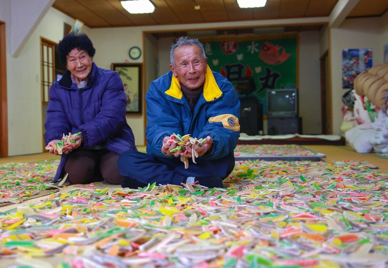 へぎ餅を大広間いっぱいに広げて乾燥させる浅尾さん夫婦=鳥羽市浦村町今浦で