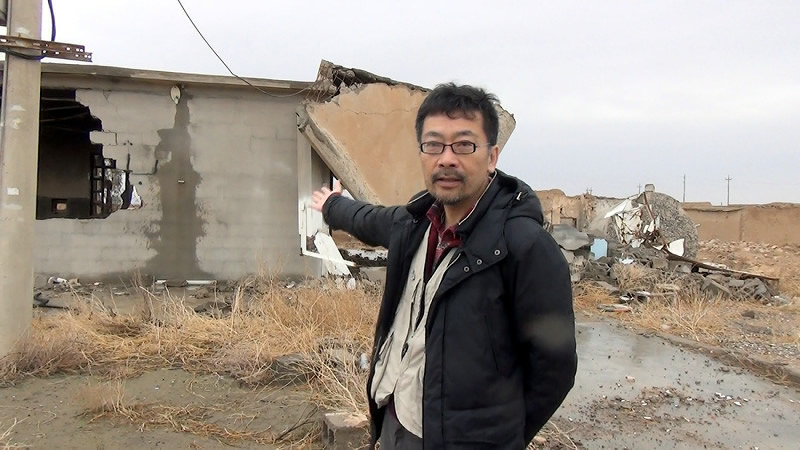 イラクの最前線、ルワラの破壊された家屋の前でリポートする西谷文和さん=西谷文和さん撮影