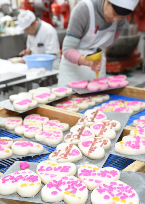 ハート形のかまぼこに「LOVE」や「ありがとう」というメッセージを入れる従業員=気仙沼市南町で2017年2月7日午前11時10分、三浦研吾撮影