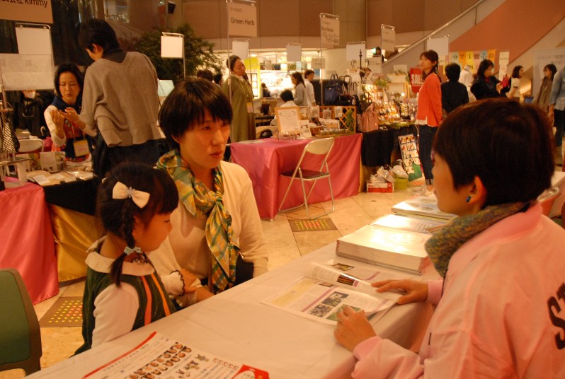 相談窓口で県よろず女子会メンバーと話をする参加者(中央)