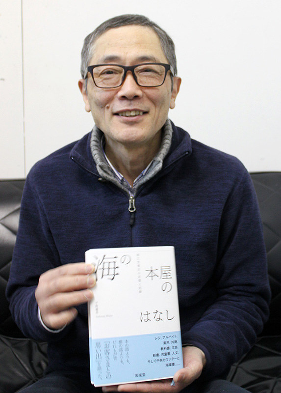 著書を手にする平野義昌さん。みなと元町タウン協議会のタウンニュースに「海という名の本屋が消えた」を連載中=神戸市中央区で、木田智佳子撮影