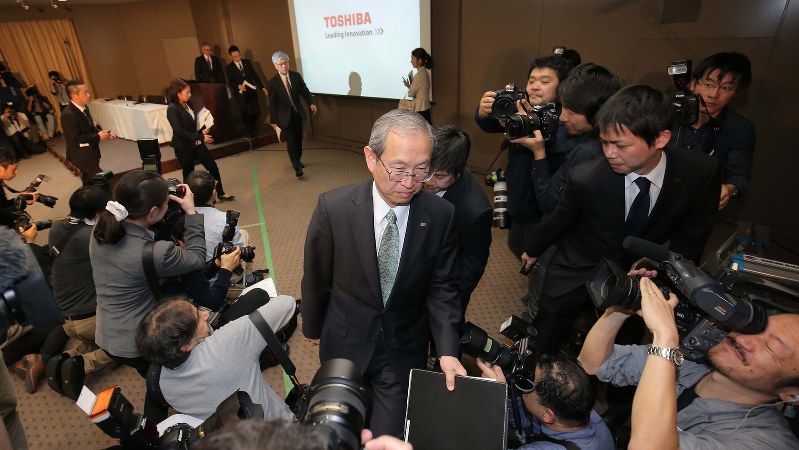 記者会見場を後にする東芝の綱川智社長(中央)=2017年2月14日、宮武祐希撮影