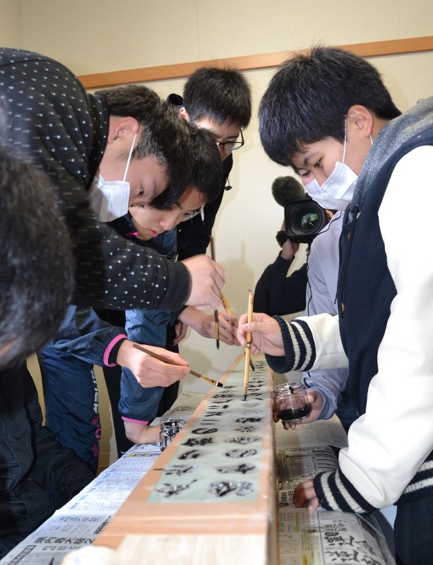 「誰かの命を助けたいなら 代わりのない自分から」。考えた津波の教訓を木碑に書き込む県立大槌高校の生徒たち=岩手県大槌町安渡で、2017年2月25日午前11時30分、中尾卓英撮影