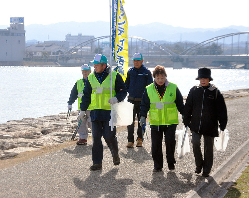 路面に気を配りながらごみ拾いをして歩くボランティアの参加者たち=大津市の瀬田川沿いで、大原一城撮影