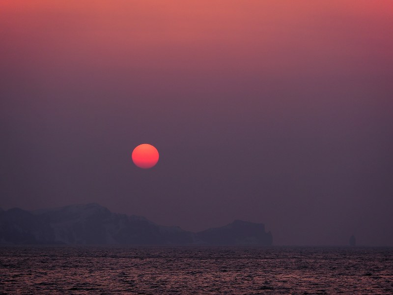 赤い太陽が冬空をあかね色に染めながら神威岬の向こう側に沈むさまを見つめていた