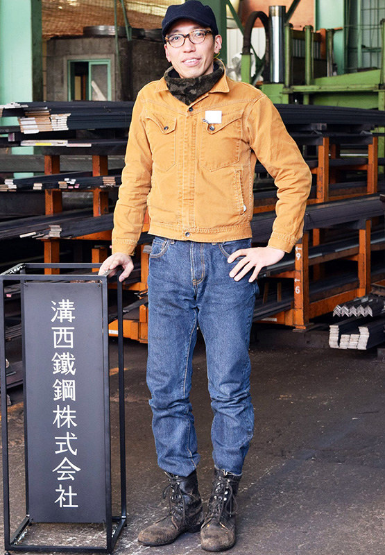 町工場で試作品の立て看板を披露する「てづくり工場組合」代表の桜井宏充さん=大阪市西区九条南4で、竹内梓撮影