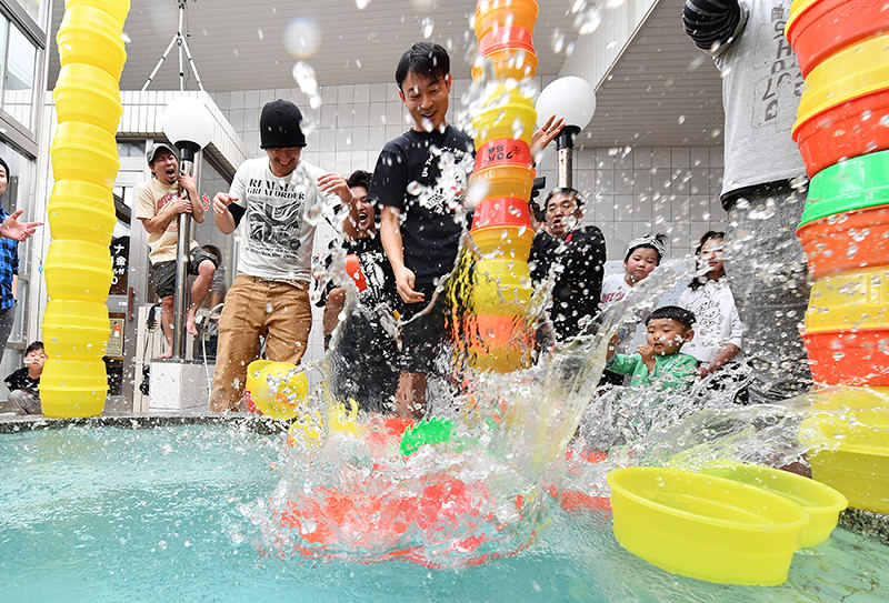 「桶タワー積み」 高く積めば積むほど倒れやすくなる=大阪市住吉区の朝日温泉で、小関勉撮影