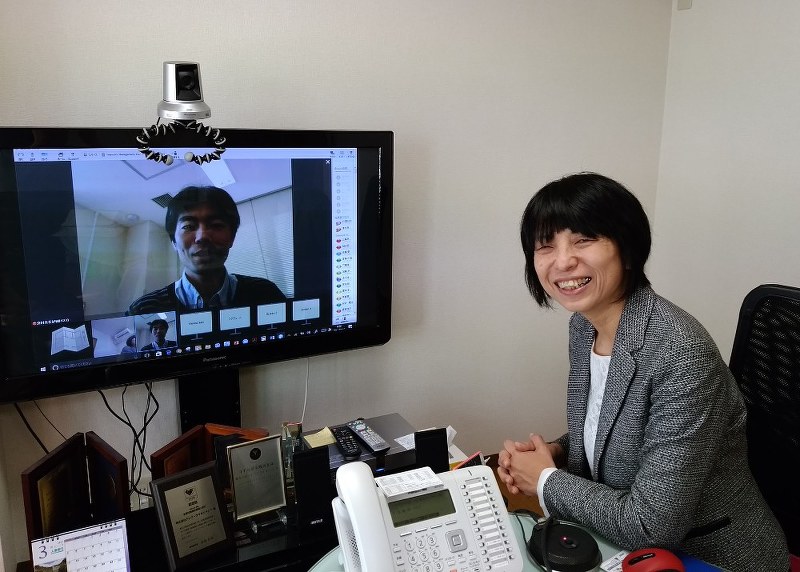 ネット回線を使って奈良県で働く社員の津村真吾さんと打ち合わせをする田澤由利社長=東京都千代田区のテレワークマネジメントで
