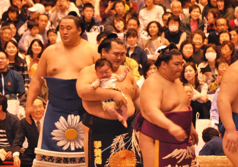 観客の子どもを抱きながら土俵入りした琴奨菊(中央)=神奈川県藤沢市で2017年4月8日午後2時ごろ、飯山太郎撮影