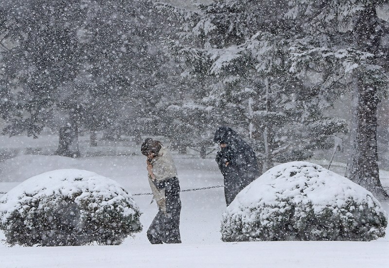 雪が吹き付ける中、先を急ぐ人たち=札幌市中央区で2017年4月13日午後、梅村直承撮影