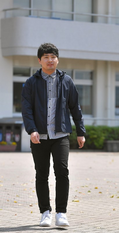 キャンパス内を歩く堤秀平さん。倒壊したアパートの下敷きになった両脚は、自転車をこげるまでに回復した=熊本市東区の東海大で2017年4月15日午後1時26分、徳野仁子撮影