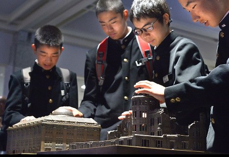 被爆前後の原爆ドーム（旧広島県産業奨励館）の模型を並べた展示コーナー「ふれるヒロシマ」で、原爆の威力を体感する生徒たち=広島市中区で２０１７年４月２６日午前８時５４分、山田尚弘撮影