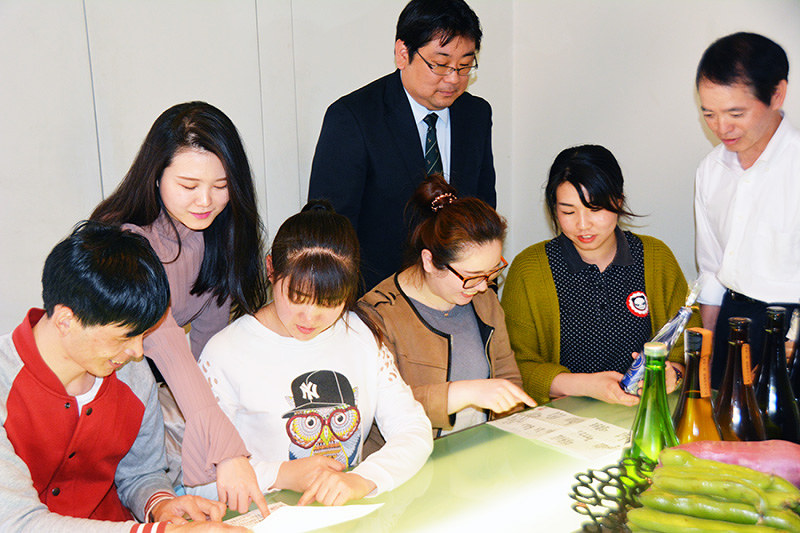 鮨ふじ田のメニューを見ながら意見を出し合う留学生ら=大阪府泉佐野市上町3の鮨ふじ田で、井川加菜美撮影