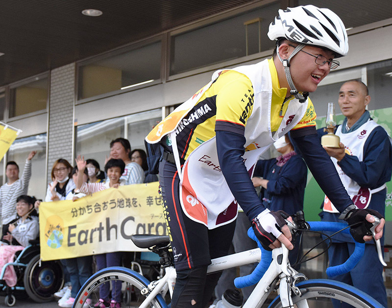 福祉作業所「メロディ」で、仲間に迎えられるピースサイクリング第一走者の辻雄太さん=広島市南区で、小山美砂撮影
