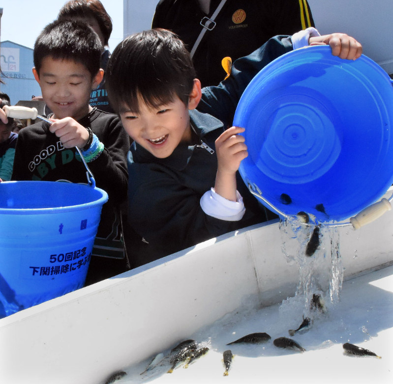 稚魚を放流する子供=2017年4月29日午前11時39分、佐藤緑平撮影