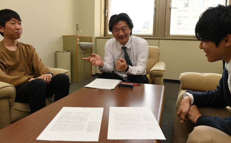 憲法9条に関して討議する谷口功一教授(中央)。左は学生の庄司総一郎さんと内田琢也さん(右端)=東京都八王子市の首都大学東京南大沢キャンパスで2017年4月28日、宮本明登撮影