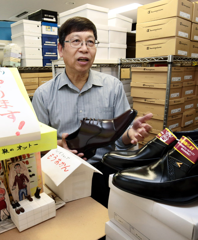 「靴のオットー」を期間限定で再開する司法書士の小山秀司さん。事務所には靴が並び、自作の紙製の店舗が置かれていた=大阪市北区で2017年5月2日、貝塚太一撮影