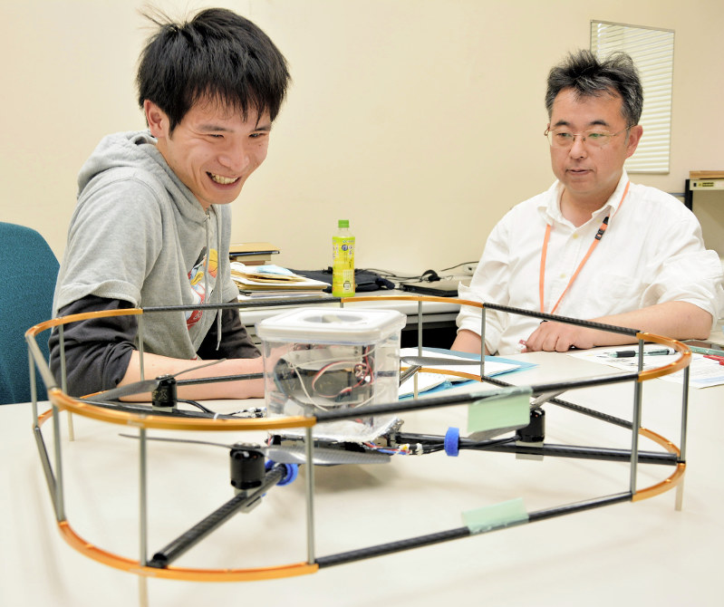 水空両用ドローン(手前)を開発している徳島大大学院の本多智貴さん(左)と三輪昌史准教授=徳島市南常三島町2の徳島大常三島キャンパスで2017年5月8日、河村諒撮影