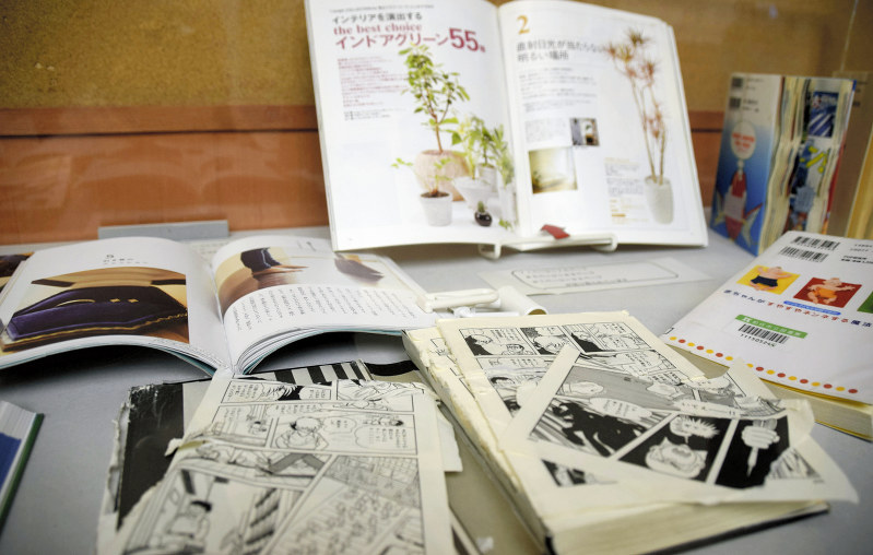 企画展では、切り取られたり、破られたりした本を展示している=石川県白山市古城町の市立松任図書館で