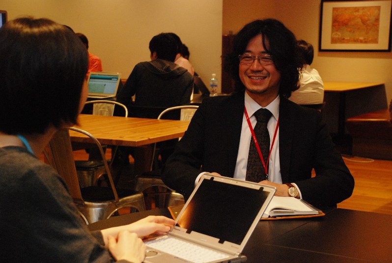 サイボウズに入社し、人事担当者(左)と打ち合わせする竹内義晴さん=東京都中央区の同社で4月25日