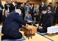 初手を指す加藤一二三九段（左）。右は藤井聡太四段＝東京都渋谷区の将棋会館で２０１６年１２月２４日午前１０時、猪飼健史撮影