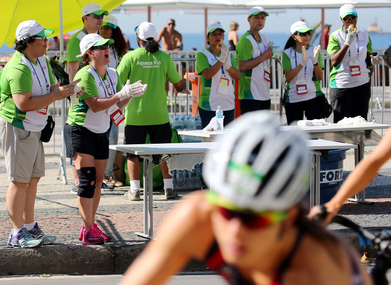 2015年のリオ五輪テストイベントで、沿道から女子トライアスロンの選手たちに大きな声をかけるボランティア=小川昌宏撮影