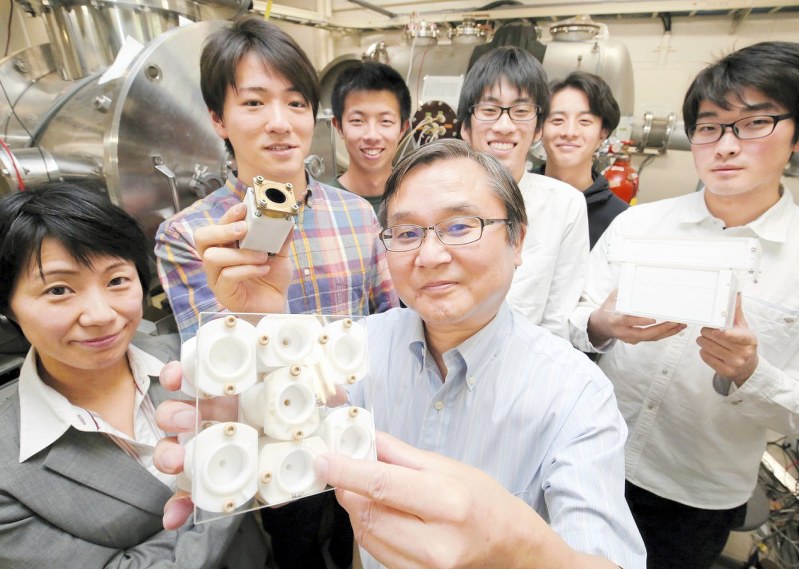 エンジンの模型を手に笑顔を見せる田原弘一・大阪工業大教授(中央)と学生たち=大阪市旭区で2017年5月1日、菅知美撮影