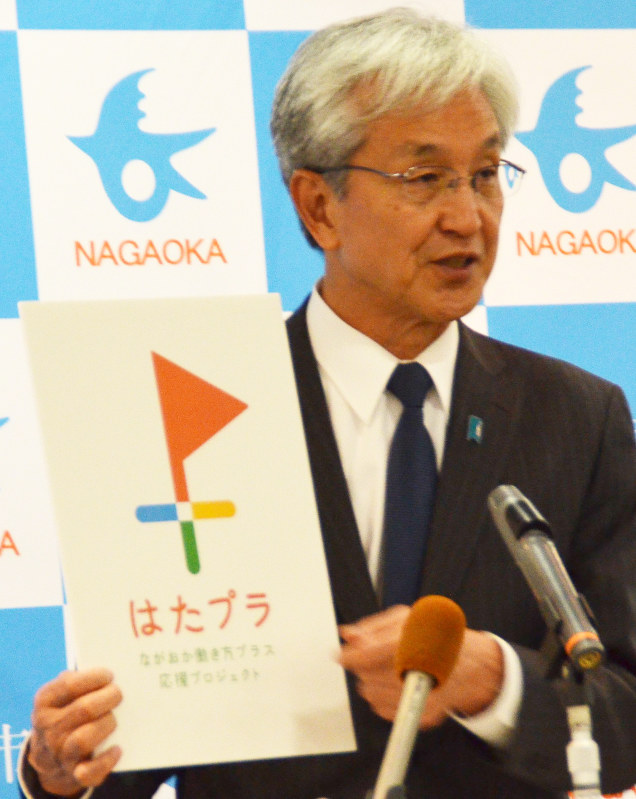 プロジェクトのマークをかざす磯田市長=アオーレ長岡で