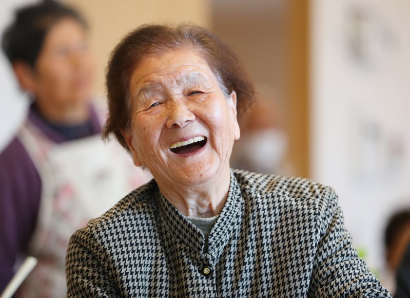 桜塚地区の集会所で開かれた花見会に参加した鈴木ふちいさん。集会所でのイベントに参加したのは初めてだったが、住民らと輪投げで遊び、笑顔を見せた=4月