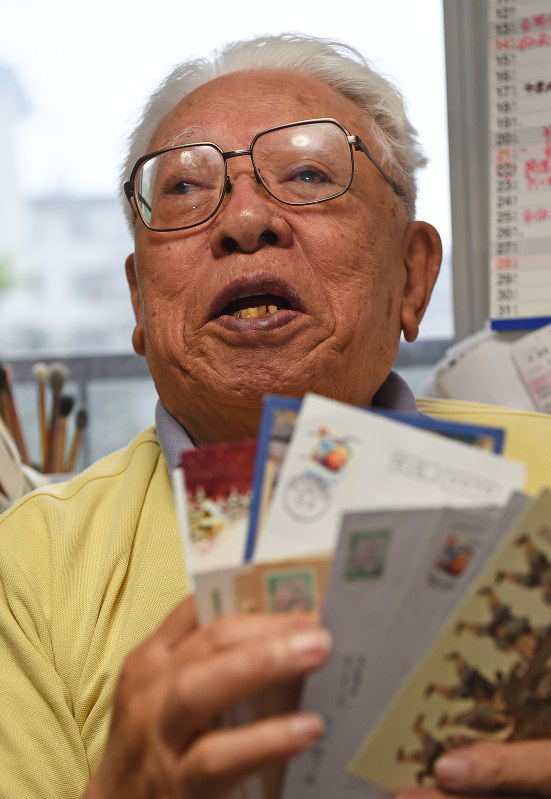 はがきを手に当時を振り返る西山進さん=福岡市南区で、矢頭智剛撮影