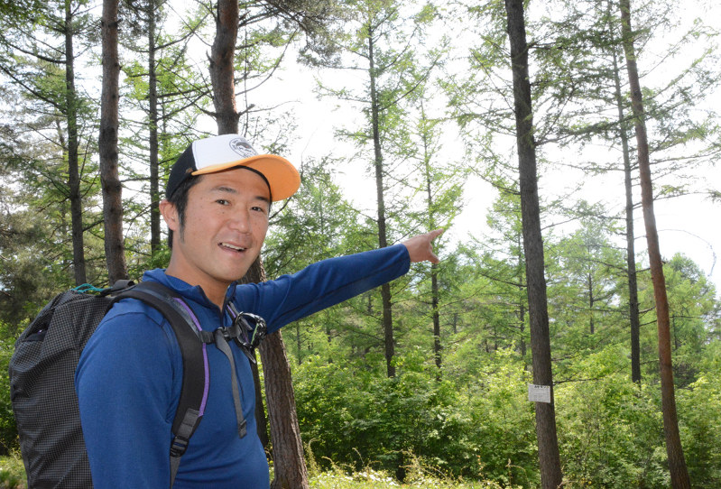山の歴史を説明する信州山岳高原観光特例通訳案内士の青山淳一郎さん=茅野市で