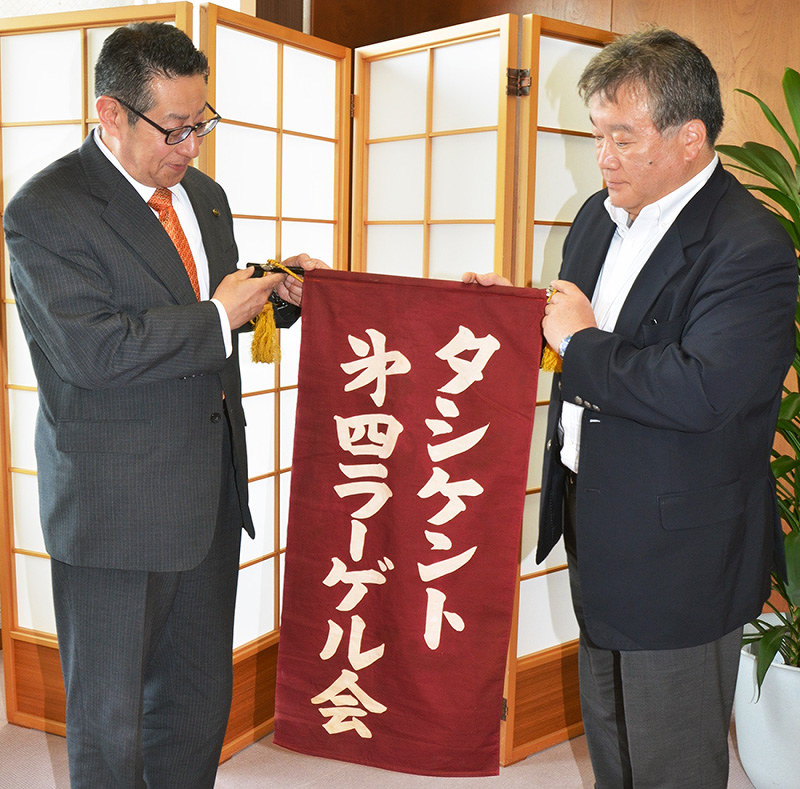 京都府舞鶴市の山口寛士副市長(左)に戦友会の旗を手渡す永田立夫さん=京都府舞鶴市役所で、鈴木健太郎撮影