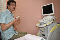 甲状腺の超音波検査装置を手にする院長の藤田操さん＝いわき市小名浜花畑町の「たらちねクリニック」で