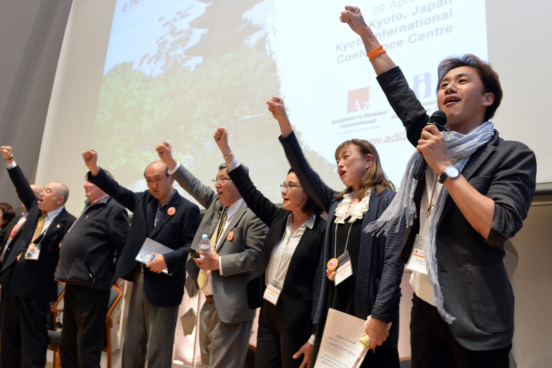 ADI国際会議で拳を突き上げる丹野智文さん(右端)ら=京都市の国立京都国際会館で4月28日、小松雄介撮影