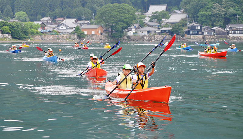 学校前の浜を漕ぎ出して鏡のような湖上を進むマキノ東小児童のカヤック=滋賀県高島市マキノ町海津沖で、塚原和俊撮影