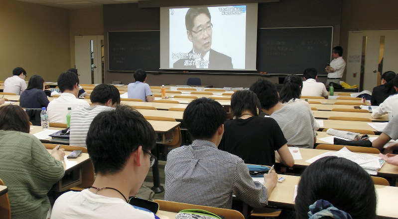 テレビニュースを比較する学生たち=明治大学で