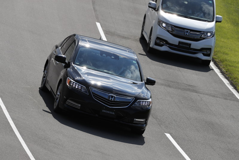 ドライバーがハンドルやペダルを操作しなくてもスムーズに先行する車を追い越すテスト車両(左)=ホンダ提供