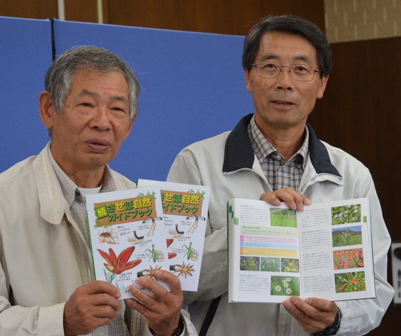 続させぼ自然ガイドブックを披露する川内野会長(左)