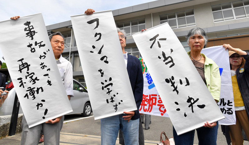 九州電力玄海原発3、4号機の再稼働差し止めを求めた仮処分申請が認められず、抗議の垂れ幕を掲げる申立人ら=佐賀市の佐賀地裁前で2017年6月13日午前10時8分、森園道子撮影